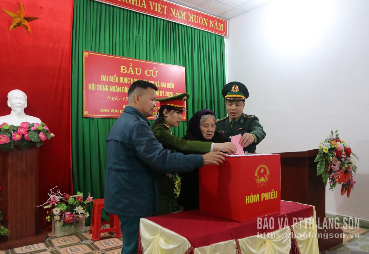 Thành viên tổ bầu cử khu vực số 23 và lực lượng chức năng hỗ trợ cử tri cao tuổi bỏ phiếu bầu cử