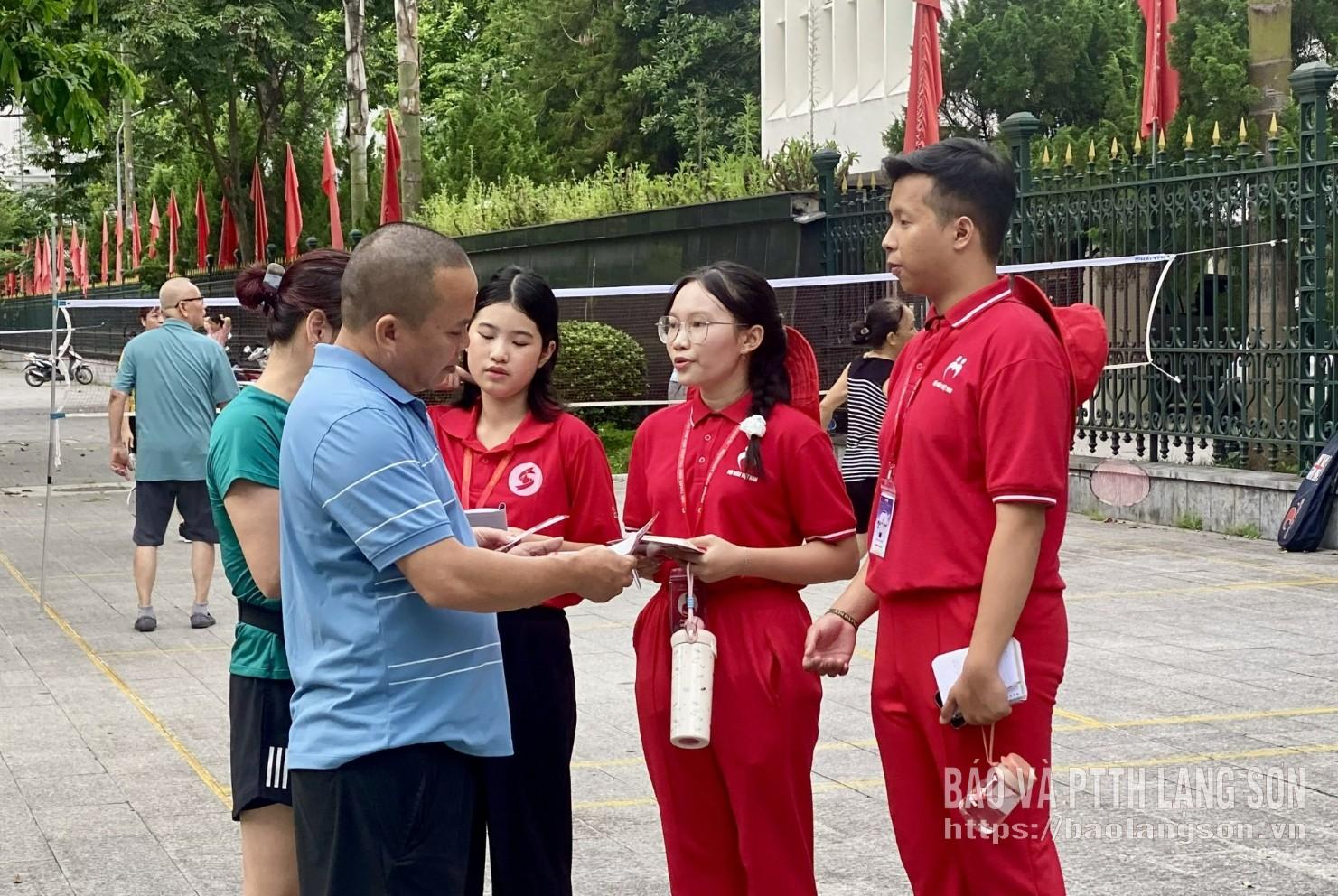 Các tình nguyện viên Hành trình Đỏ tham gia tuyên truyền, phát tờ rơi đến người dân tại tuyến đường Quang Trung, phường Lương Văn Tri