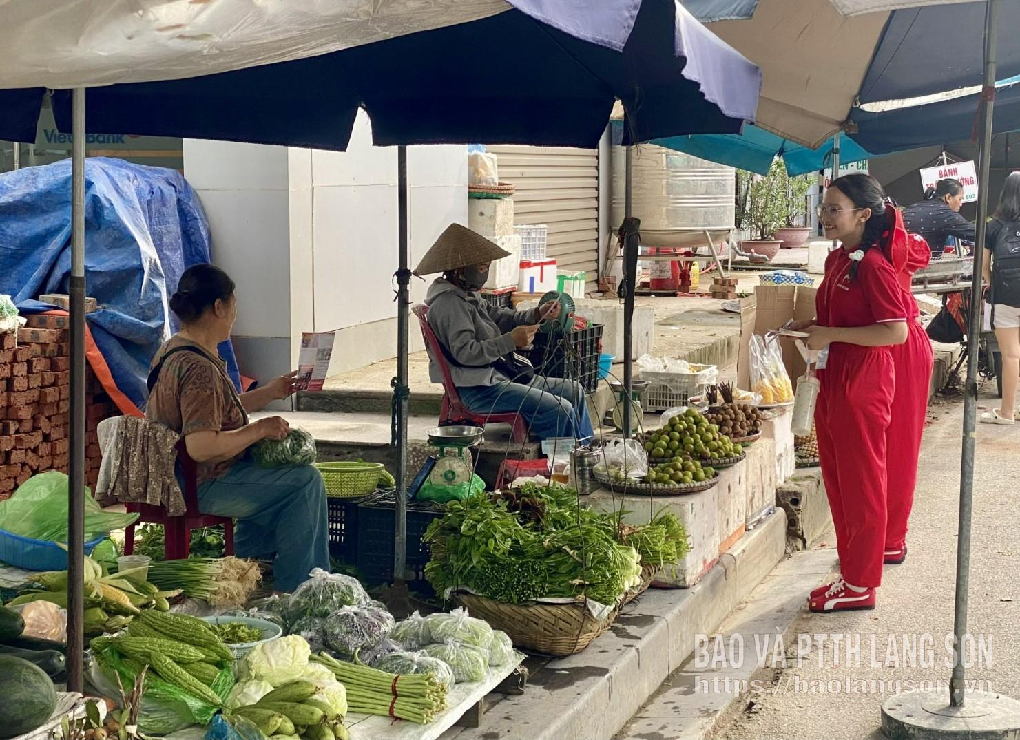 Các tình nguyện viên Hành trình Đỏ tham gia tuyên truyền, phát tờ rơi đến người dân tại Chợ Chi Lăng, phường Lương Văn Tri